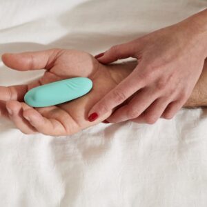 un sextoy godemichet bleu est posé dans la main d'un homme