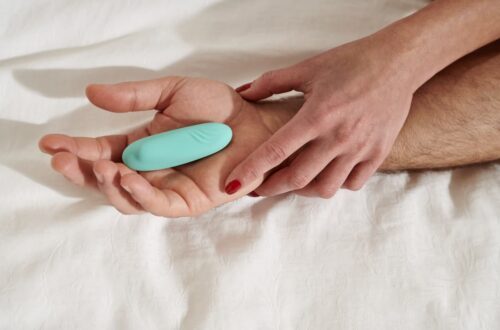 un sextoy godemichet bleu est posé dans la main d'un homme