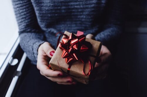 une femme tiens un cadeau pour offrir à son collègue