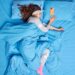 femme-dormant-paisiblement-dans-des-draps-bleus